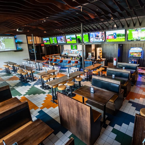 Highline Park bar-and-grill interior with multiple TVs, a bar, and various seating arrangements.