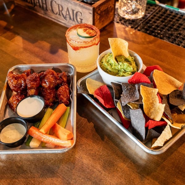 Highline Park's chicken wings with ranch, carrots, celery, guacamole, and colorful tortilla chips.