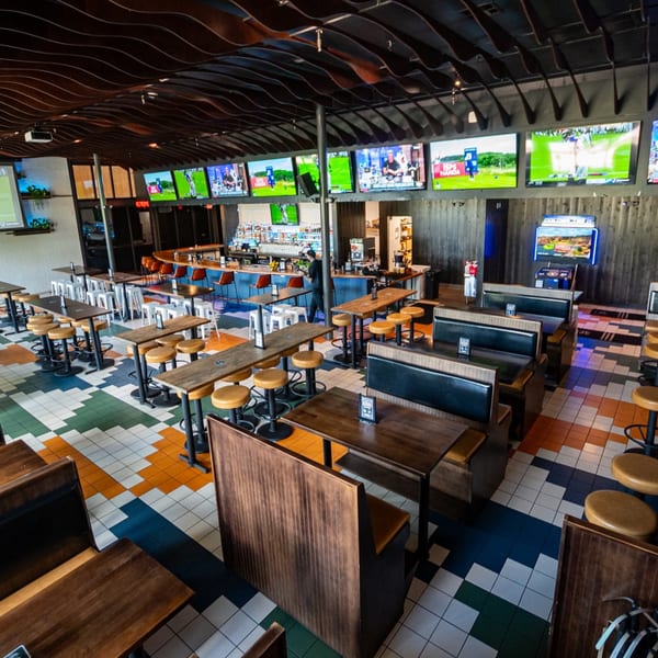 Highline Park bar-&-grill interior with multiple TVs, a long bar, and various seating arrangements.